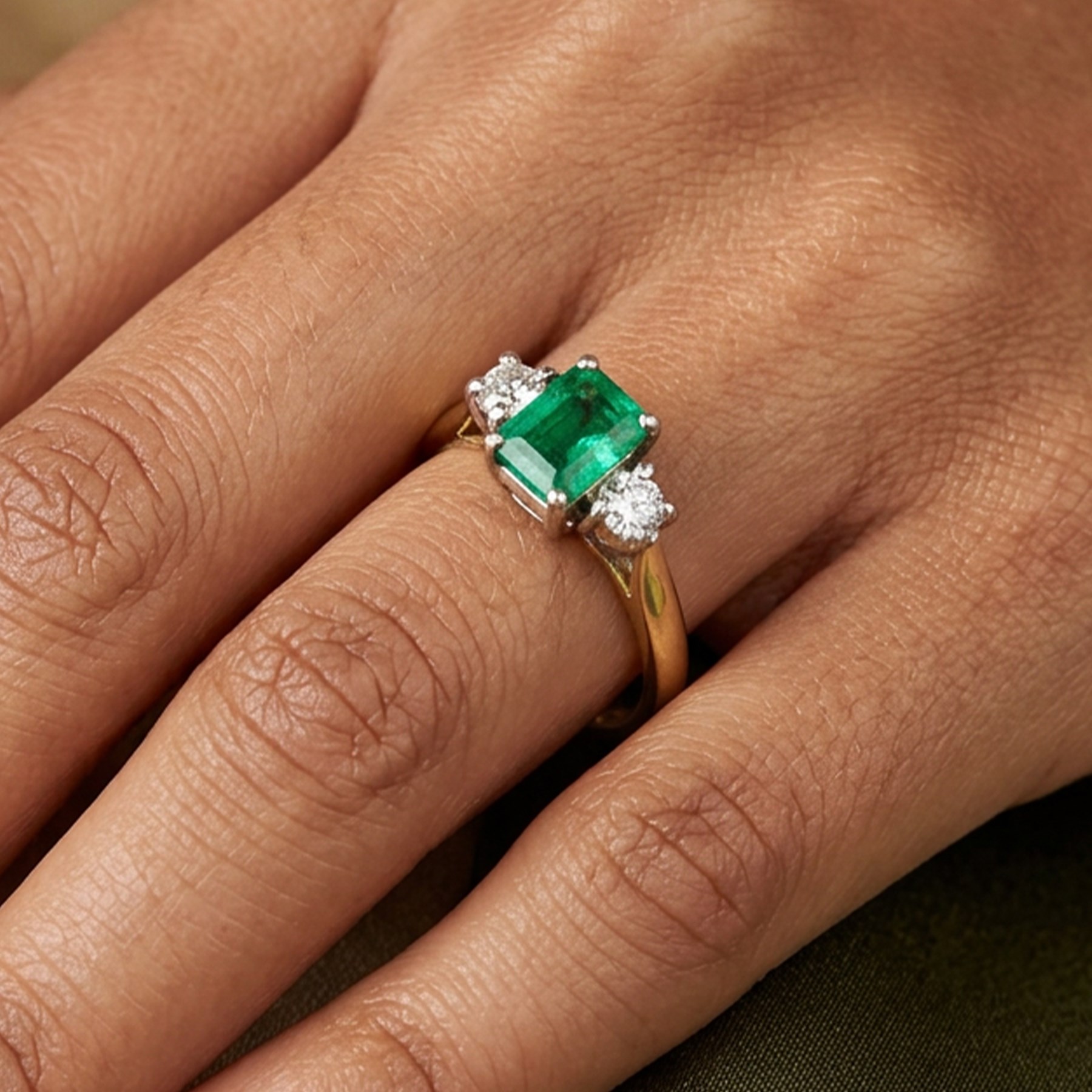 18ct gold emerald and diamond three stone ring, single octagonal cut emerald of approx 0.40 carat, with a round brilliant cut diamond set either side, Birmingham 1997, total diamond weight approx 0.15 carat