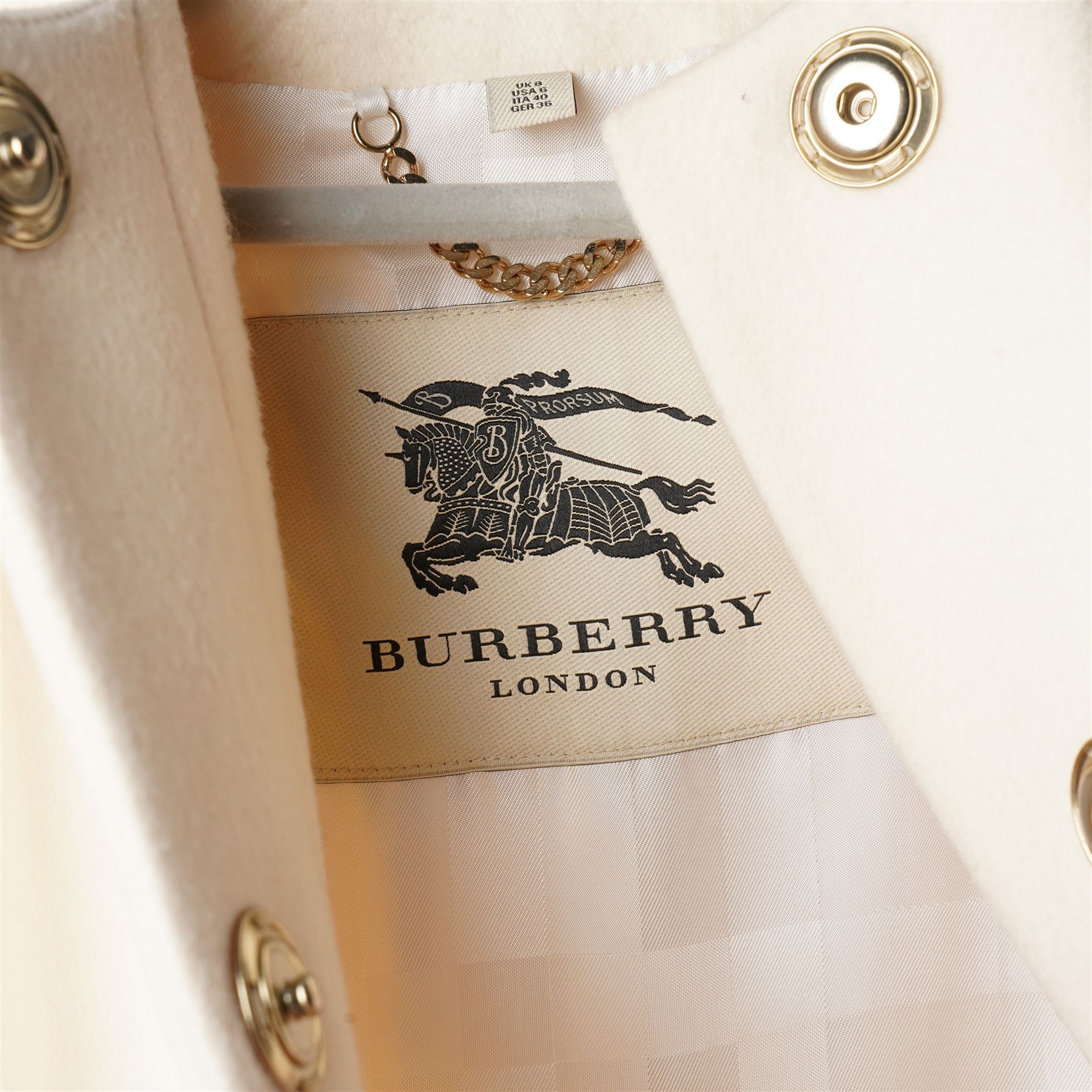 Burberry London - wool coat in cream, with concealed front popper fastening, bracelet-length sleeves with tab and black button detail and side slip pockets, with slit to back, size 40, unused with original Harvey Nichols garment bag and hanger