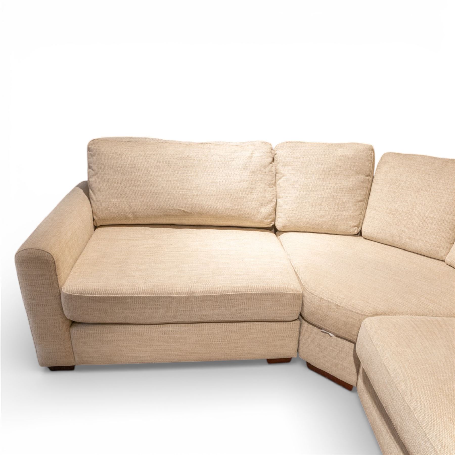 Contemporary modular corner sofa, upholstered in neutral fabric, with curved back fitted with loose cushions and wide seat pads, padded scroll arms and block feet, designed as three detachable sections