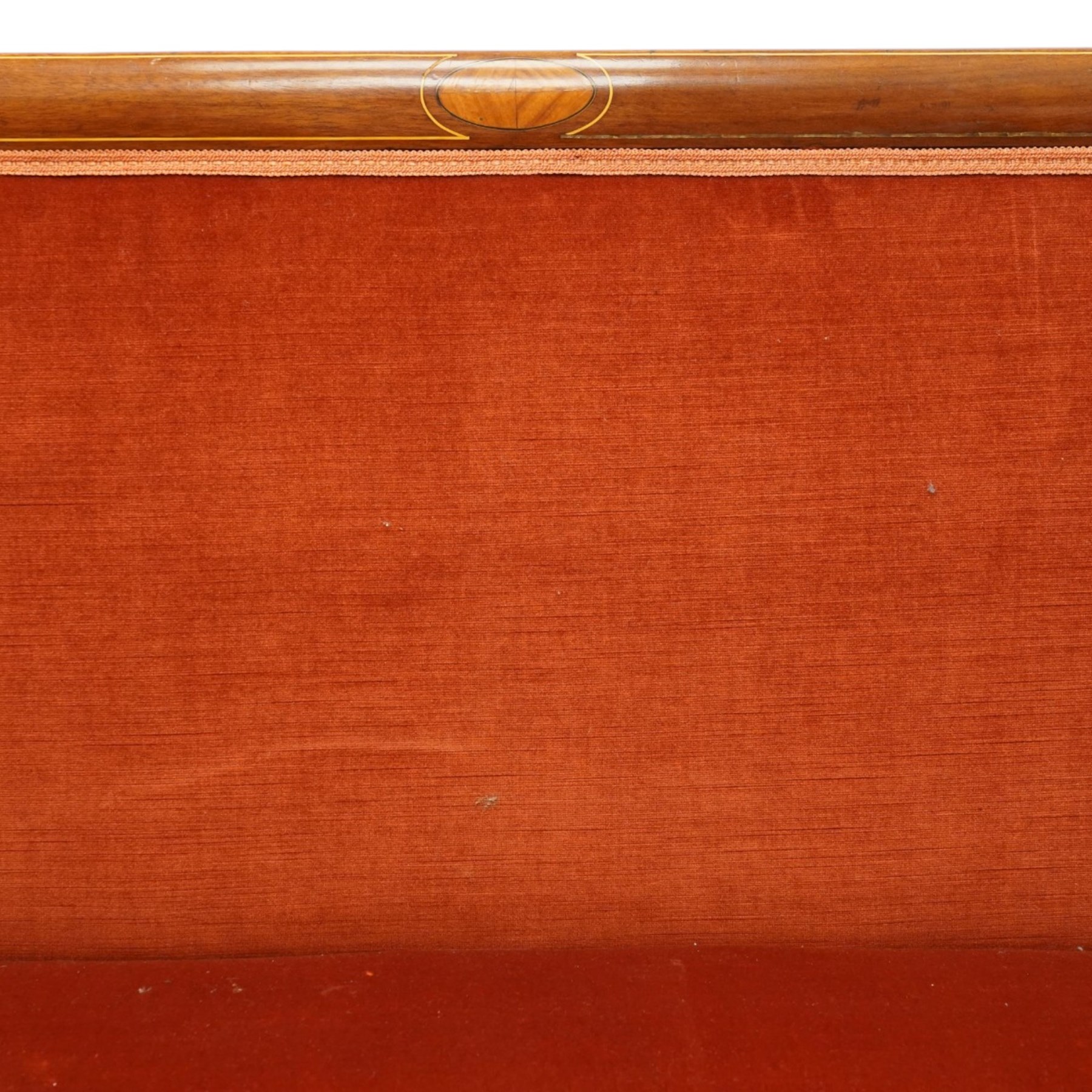 Edwardian inlaid mahogany tub two seater settee, traditional shape with satinwood stringing, upholstered in crimson fabric with sprung seat, on square tapering supports with castors