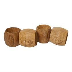 Mouseman - four light oak napkin rings, of bulbous octagonal form with signature mouse carving by Robert Thompson of Kilburn
