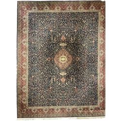 Persian design indigo ground carpet, central crimson pole medallion surrounded by trailing foliate decoration, the guarded border with repeating scrolling palmette motifs