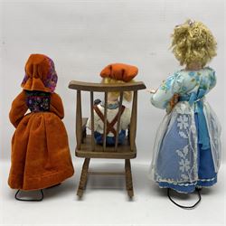 Anna Meszaros Hungary - three hand made needlework figurines - 'The Cobbler' as a child seated in a wooden rocking chair working on a removed boot H24cm; young girl standing crying holding a doll with broken head H32cm; and young girl in long dress and bonnet standing holding a doll H27cm (3)  Auctioneer's Note: Anna Meszaros came to England from her native Hungary in 1959 to marry an English businessman she met while demonstrating her art at the 1958 Brussels Exhibition. Shortly before she left for England she was awarded the title of Folk Artist Master by the Hungarian Government. Anna was a gifted painter of mainly portraits and sculptress before starting to make her figurines which are completely hand made and unique, each with a character and expression of its own. The hands, feet and face are sculptured by layering the material and pulling the features into place with needle and thread. She died in Hull in 1998.