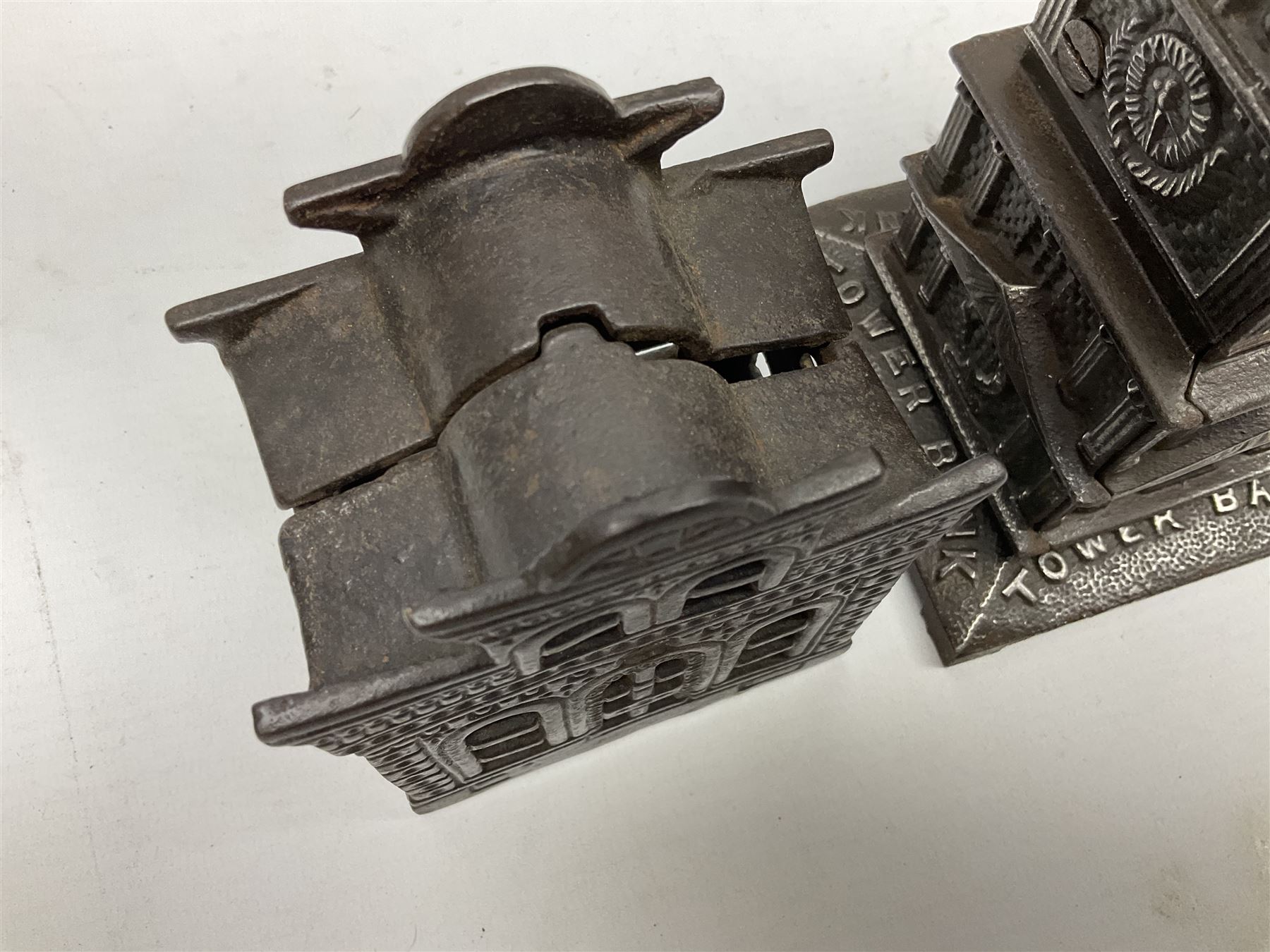 Five early 20th century cast-iron money banks as buildings - 'City Bank' c1904 H10cm; 'County Bank' c1905 H11cm; 'Town Hall Bank' c1900 H8.5cm; 'Tower Bank' c1902 H23.5cm; all made by John Harper; and 'Blackpool Tower Bank' c1907 by Chamberlain & Hill H18.5cm (5)