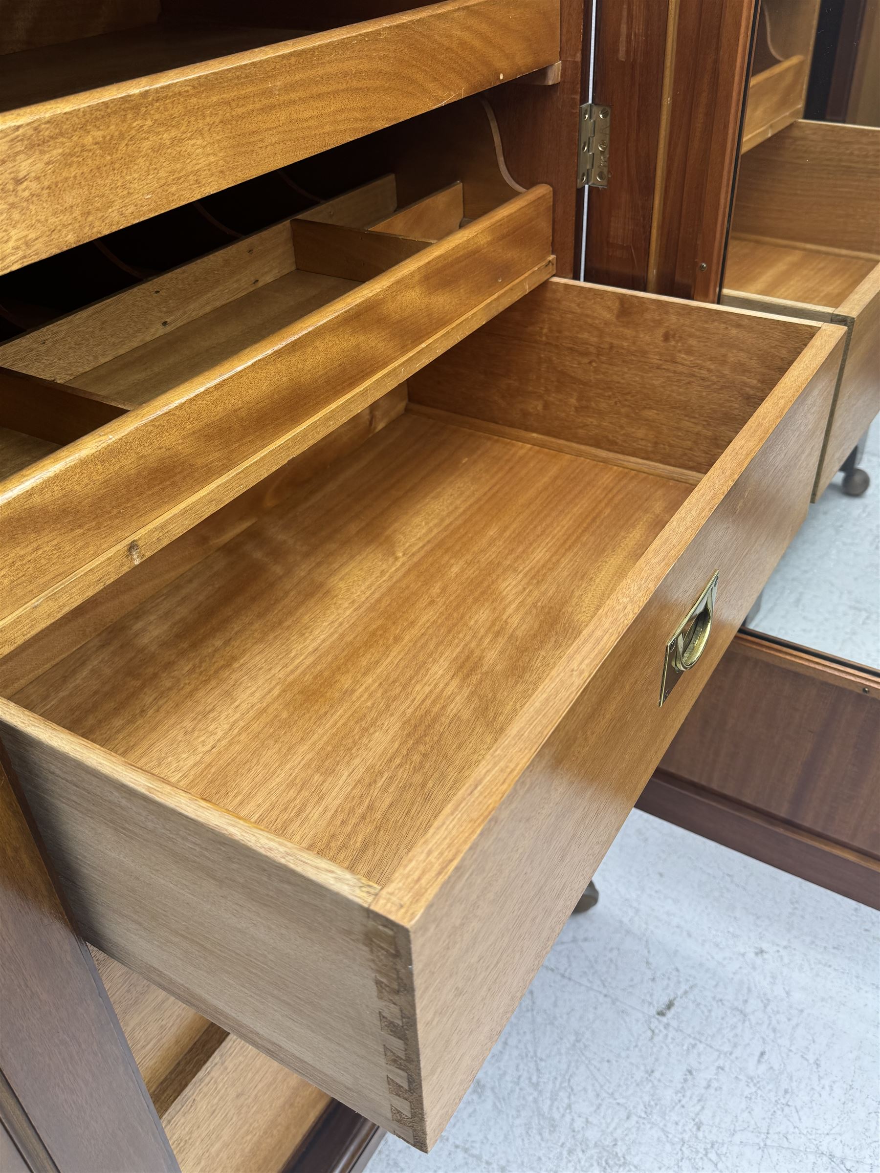 Wylie & Lochhead, Glasgow - early 20th century mahogany and satinwood double wardrobe, projecting cornice over panelled doors, interior fitted with mirrored door, shelves, drawers, hooks and hanging rail, raised on bracket supports with ceramic castors