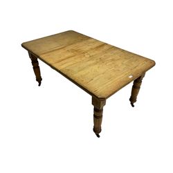 Late Victorian pine extending dining table, rectangular moulded top with canted corners and additional leaf, on turned supports with brass castors 