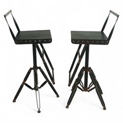 Pair of 20th century brutalist industrial metal swivel bar stools, sheet seats with strap backrests with bolted design to the sides, raised on quadripod bases with angular strut supports, the seats height-adjustable and swivelling