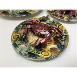 Five 20th Century Portuguese Palissy style Majolica wall plates, all depicting crustaceans to the centre modelled in relief surrounded by encrustations and shells, both with impress marks beneath, largest D29cm