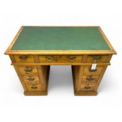 Rustic pine twin pedestal desk, rectangular green leather inset top above a central frieze drawer flanked by two short drawers, each pedestal featuring three graduated drawers, raised on a plinth base