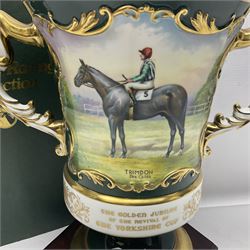 Aynsley twin handled racing cup and cover, to commemorate 'The Golden Jubilee of the Revival of The Yorkshire Cup', the handles inscribed '1927' and '1977', the green body painted by E. Woodhouse with Joe Childs up on Trimdon, the reverse with the winners, the domed cover with a Yorkshire rose finial, limited edition no. 4 of 50, on hexagonal wooden base with certificate, H34cm