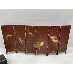  Late 19th / early 20th century Japanese lacquered table top cabinet, heavily decorated with mother of pearl inlay depicting blossoming branches, flowers and birds, the two hinged doors between longer drawers opening to reveal interior fitted with four short drawers, with lift up hinged canted lid, H28cm D9.5cm W23cm, together with mother of pearl inlaid miniature folding screen, dish decorated with walking figures with crimped edge, boxes decorated with flowers, birds and gilt etc