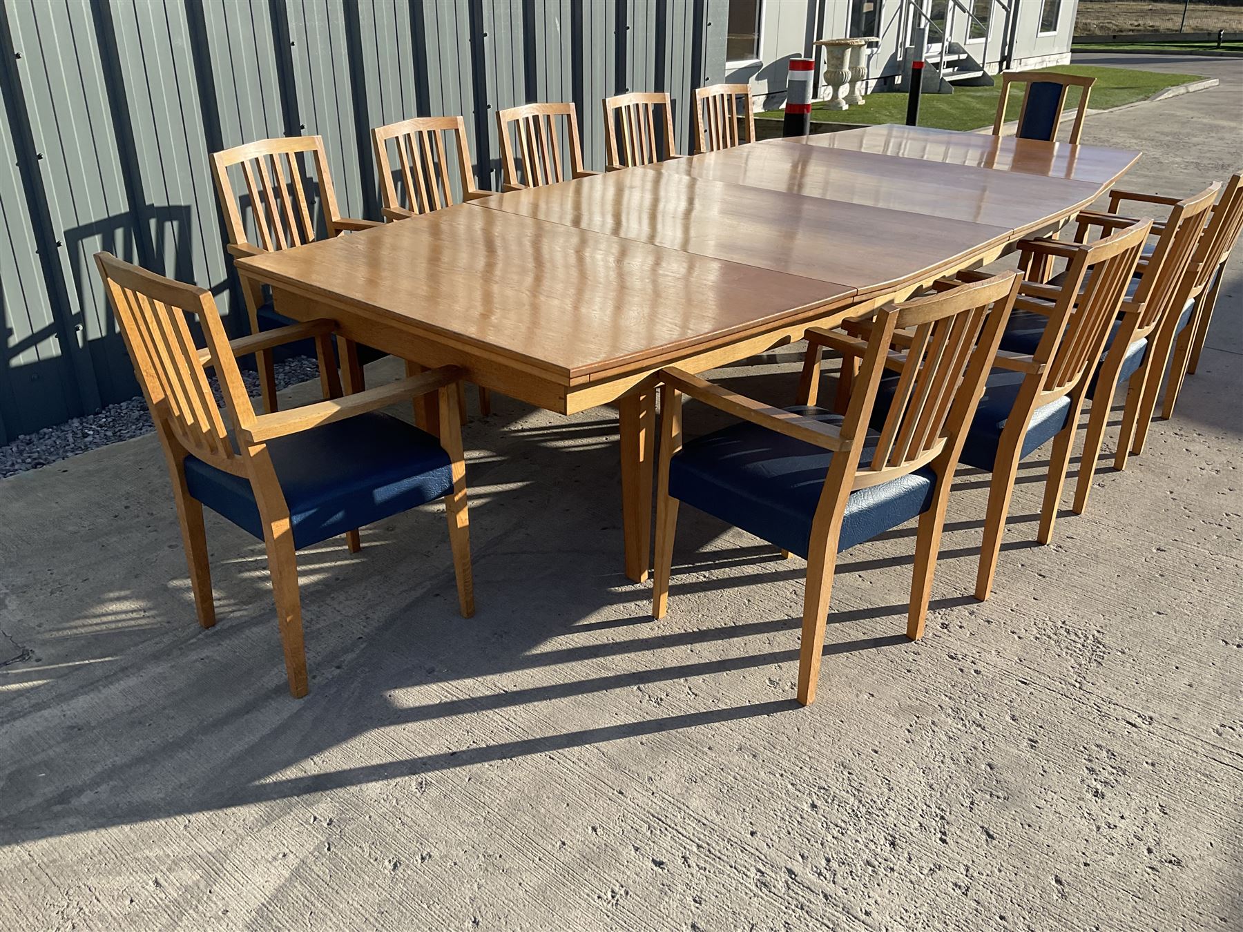 Light oak bespoke boardroom table, concave form, four sectional top on square discreet legs (12' x 5'), with twelve armchairs including 'Chairmans' chair