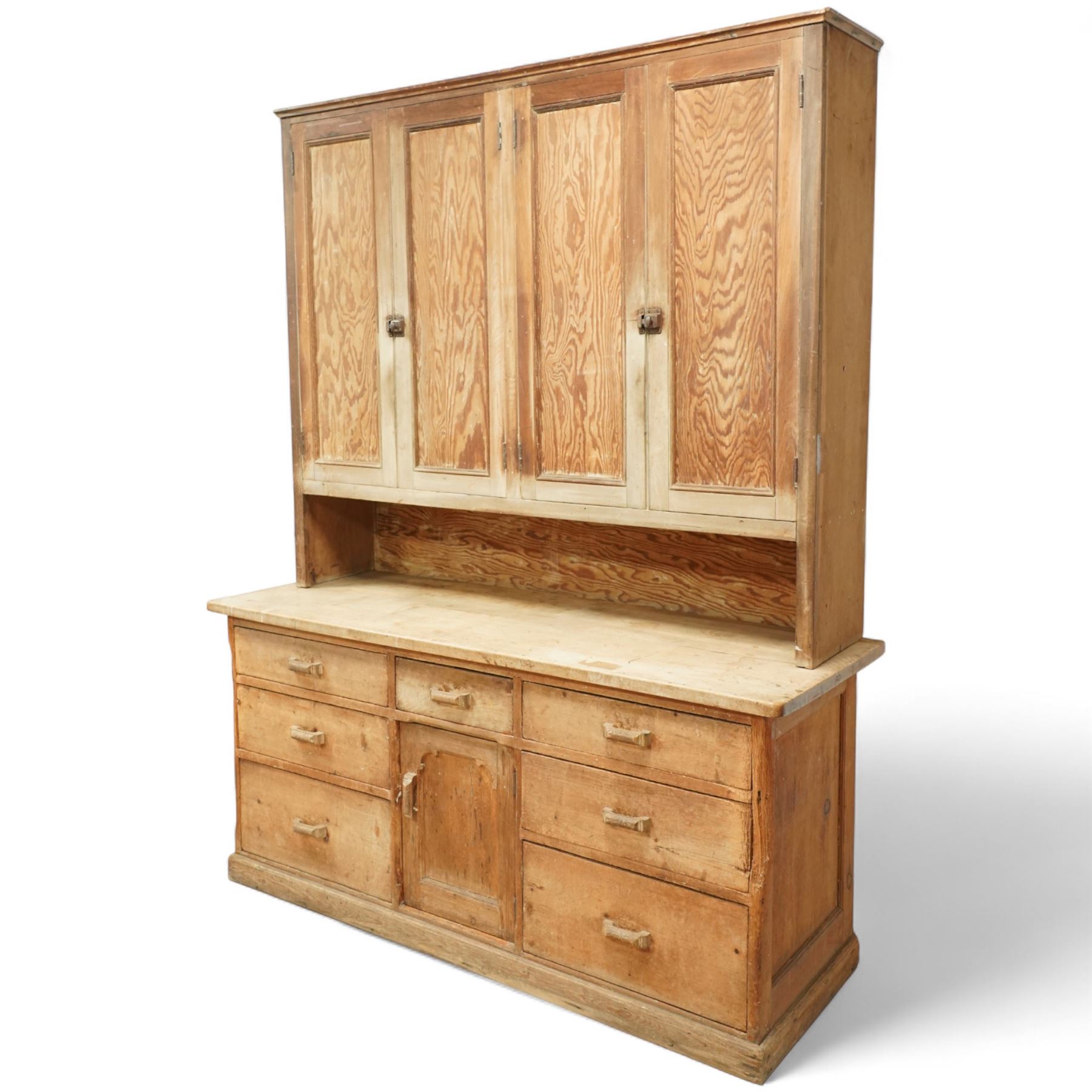 Early 20th century pine and beech kitchen dresser, projecting cornice above three panelled cupboard doors, base fitted with three drawers and twin panelled cupboards, on plinth base