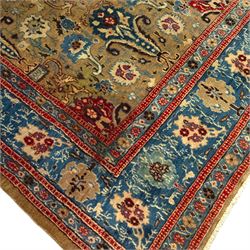 Central-Western Persian Sarouk hand-knotted carpet, beige ground, with an all-over design of boteh and floral sprays in red and blue within a floral border on blue ground 