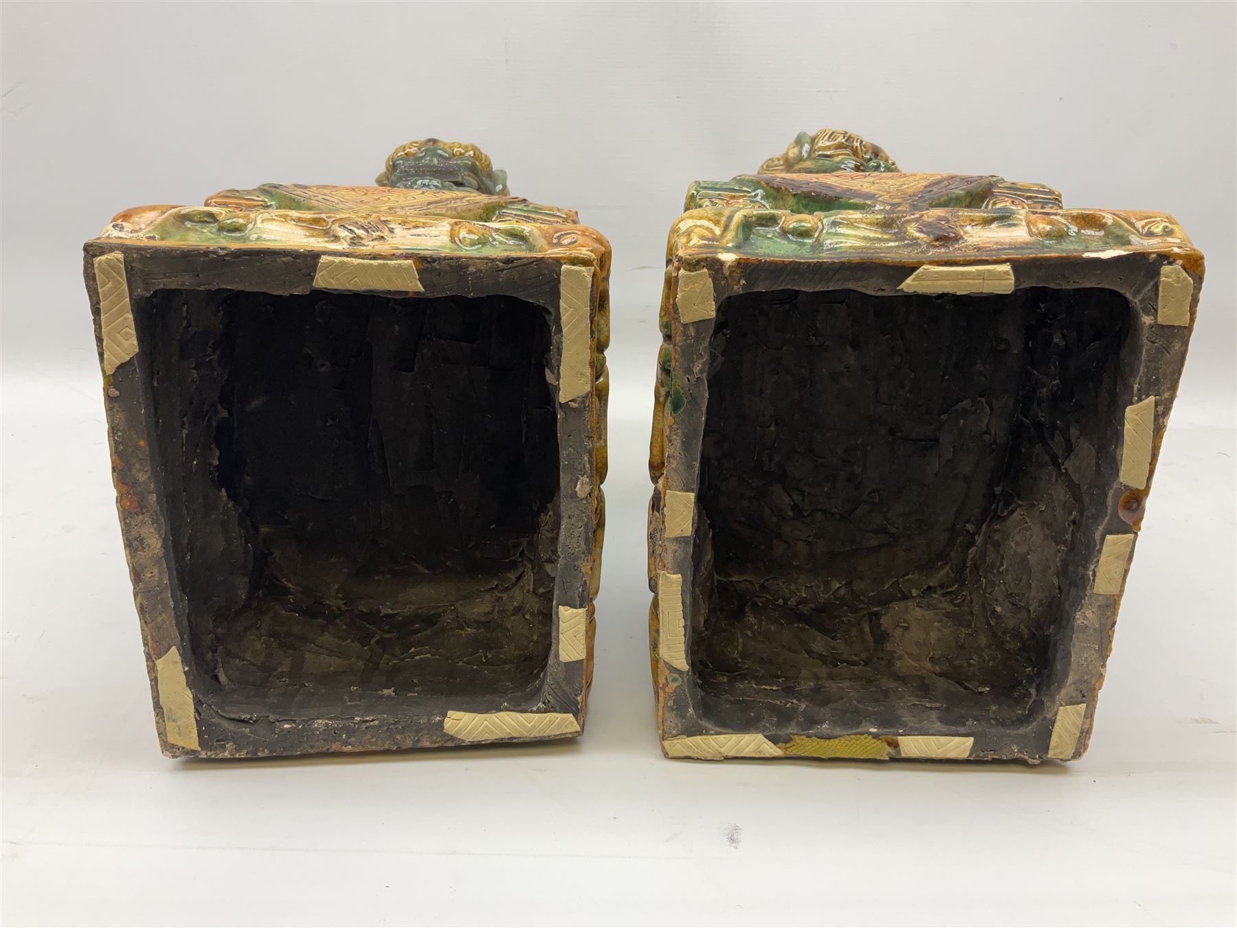 Pair of Chinese Temple Lions or Dogs of Foo, modelled in seated post, one with one front paw resting upon a ball, the other upon a cub, each upon stylised plinth base, H44cm