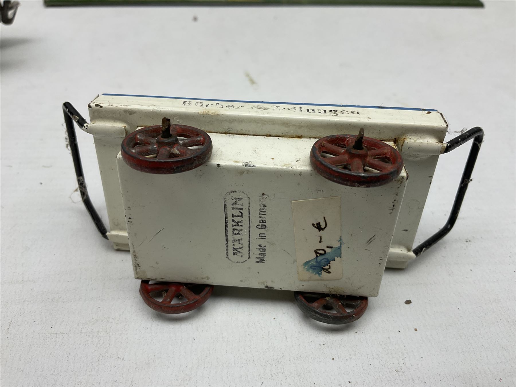 '0' gauge - Bing tin-plate two-storey double sided station with open walk-through to one end, rail side canopy, hinged doors and removable roof giving access to clock illumination L35cm; Bing hand-cranked turntable and open wagon; Marklin tin-plate level crossing barrier and Newspaper vendor's tin-plate four-wheel hand cart (5)