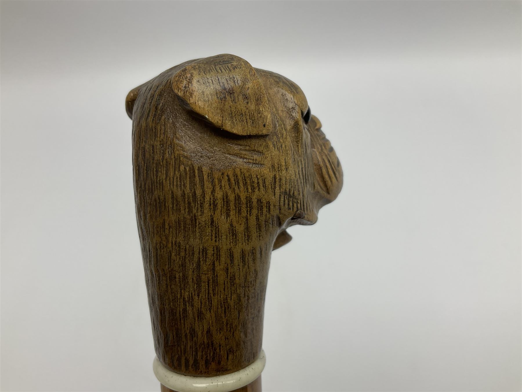 20th century walking cane, the carved wooden handle modelled as the head of a boxer dog with inset glass eyes and articulated and sprung jaw, upon a tapering Malacca shaft, L86.5cm