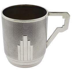 Art Deco silver christening mug, of cylindrical form with engine turned decoration to body and stylised angular handle, upon an inverted stepped foot, hallmarked Sanders & Mackenzie, Birmingham 1931, H7.5cm, approximate weight 3.21 ozt (99.9 grams)