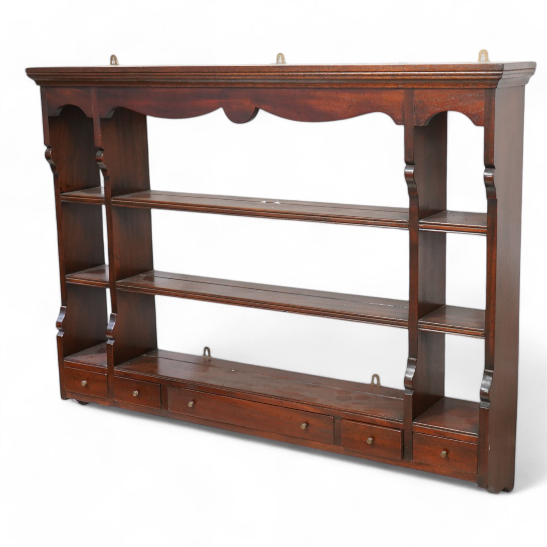Georgian design mahogany wall rack, moulded cornice over shaped frieze and thee shelves, fitted with five drawers