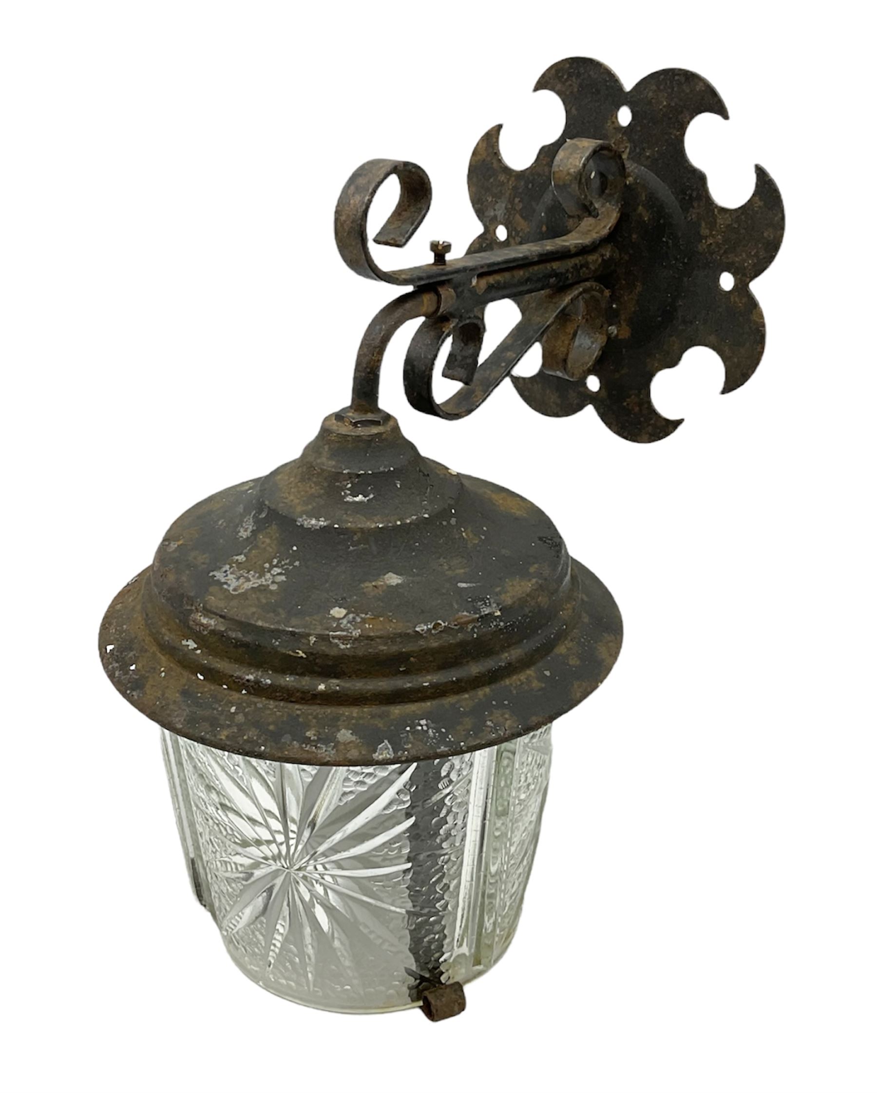 Wrought iron wall lantern with patterned glass shade of tapering cylindrical form, H29cm