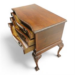 20th century oak and mahogany serpentine chest, the moulded top carved with trailing crossed ribbon and flower heads, fitted with three long cock-beaded drawers, ornate cast gilt metal handles, on acanthus leaf carved cabriole supports with ball and claw feet 