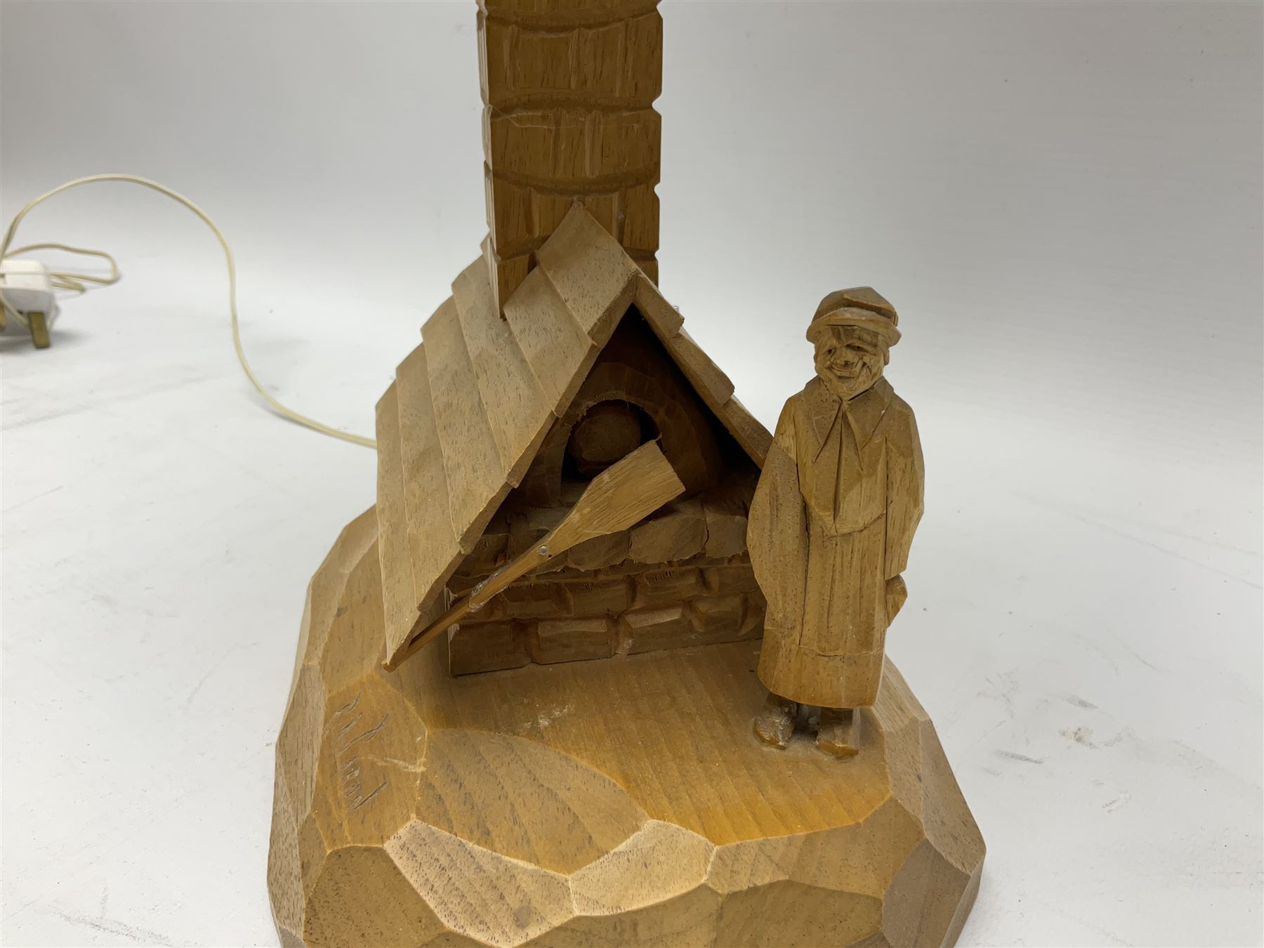 Mid 20th century Paul Caron carved table lamp, modelled as man standing before an oven, the chimney supporting the panelled shade, the base signed P.E. Caron, H42cm