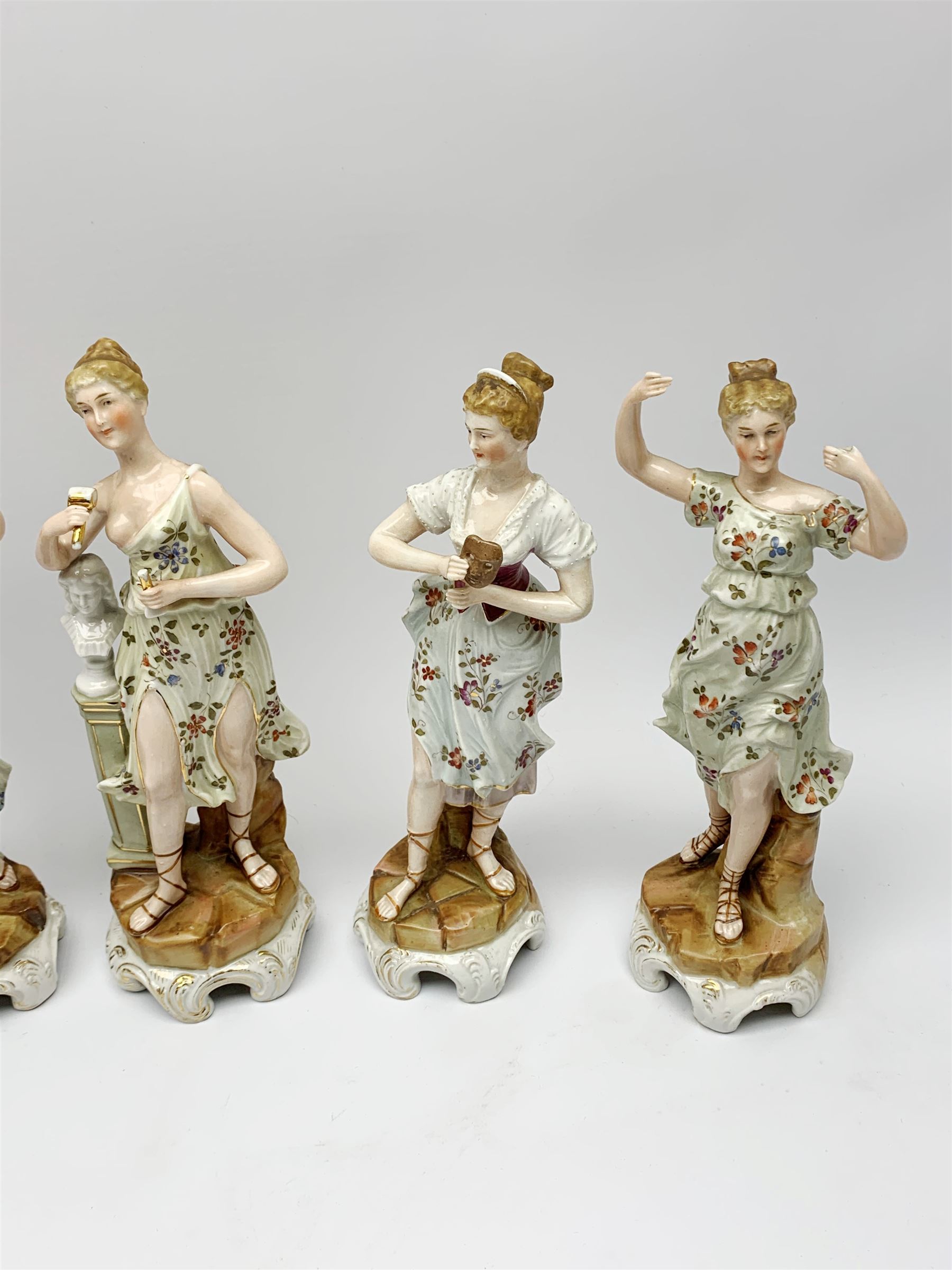 A group of five Continental figurines modelled as the arts, emblematic of music, painting, sculpture, literature, and theatre, each with spurious blue cross mark beneath, H22.5cm. (5). 