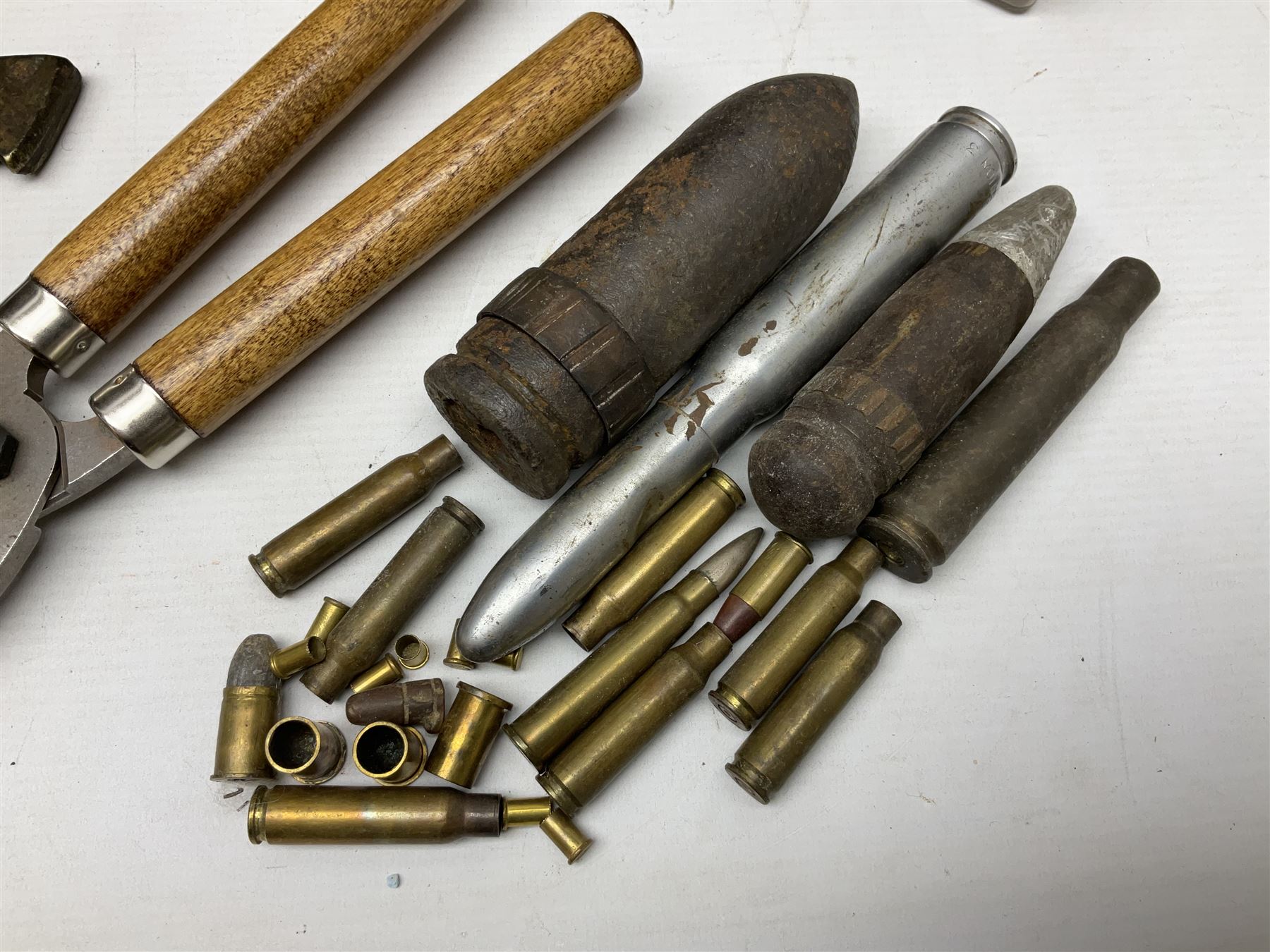 Assorted militaria including ten leather or canvas cartridge and other belts, maroon beret with 17th Lancers cap badge, modern bullet mould, leather and brass shot flask, two knives, shell cases, boomerang etc; in tin deed box