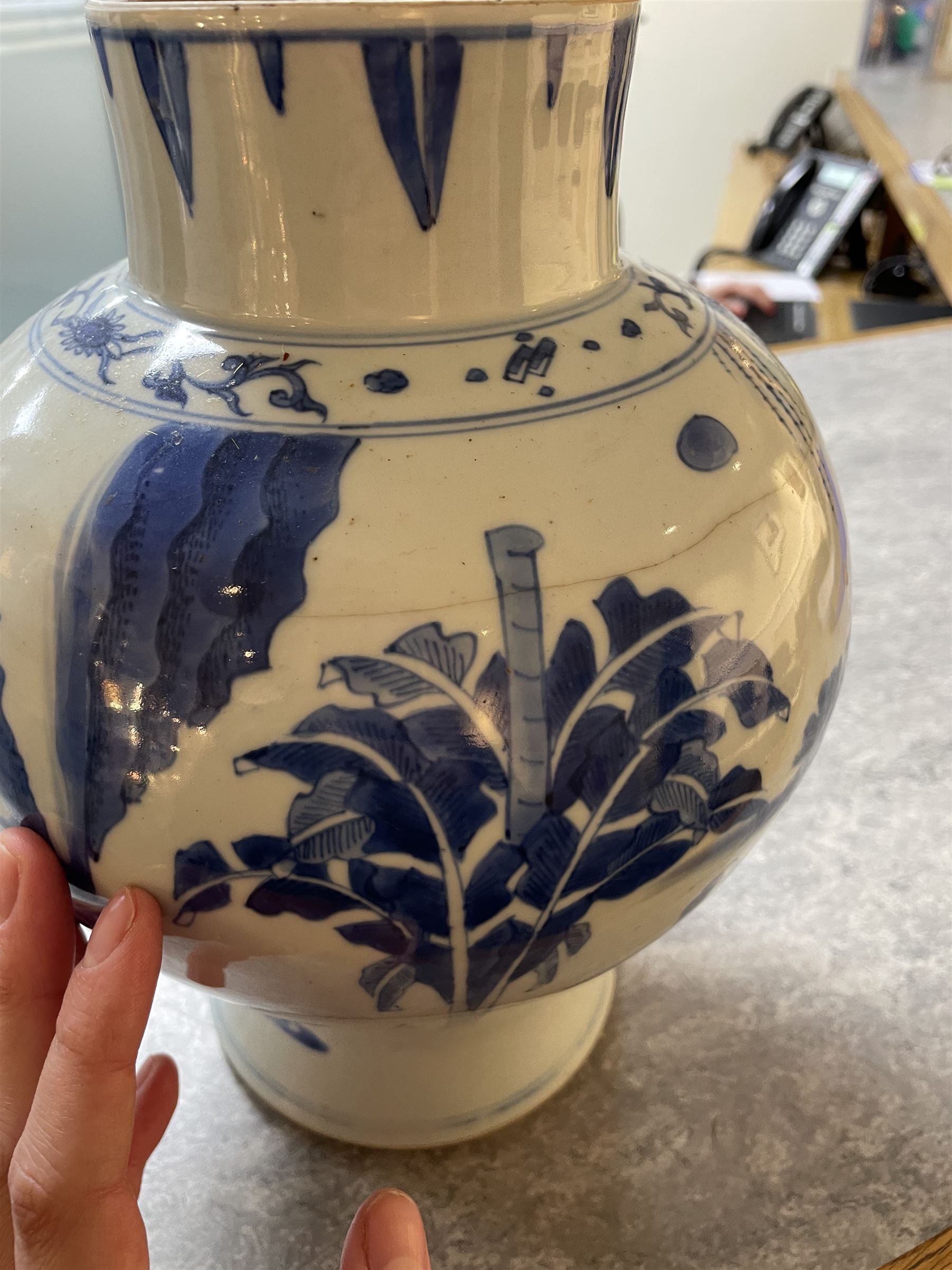 Pair of Chinese Kangxi blue and white porcelain vases, each of baluster form, painted with an outdoor scene containing figures seated upon the ground reading scrolls and holding fans, willow and bamboo tress, rock work and water, H27cm
