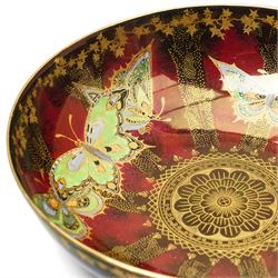 Four pieces of Fielding's Devon Lustrine, comprising a small pair of sleeve vases, H15cm; a bowl and vase, each decorated with butterflies and leaves in gilt on a red ground, printed marks beneath (4)