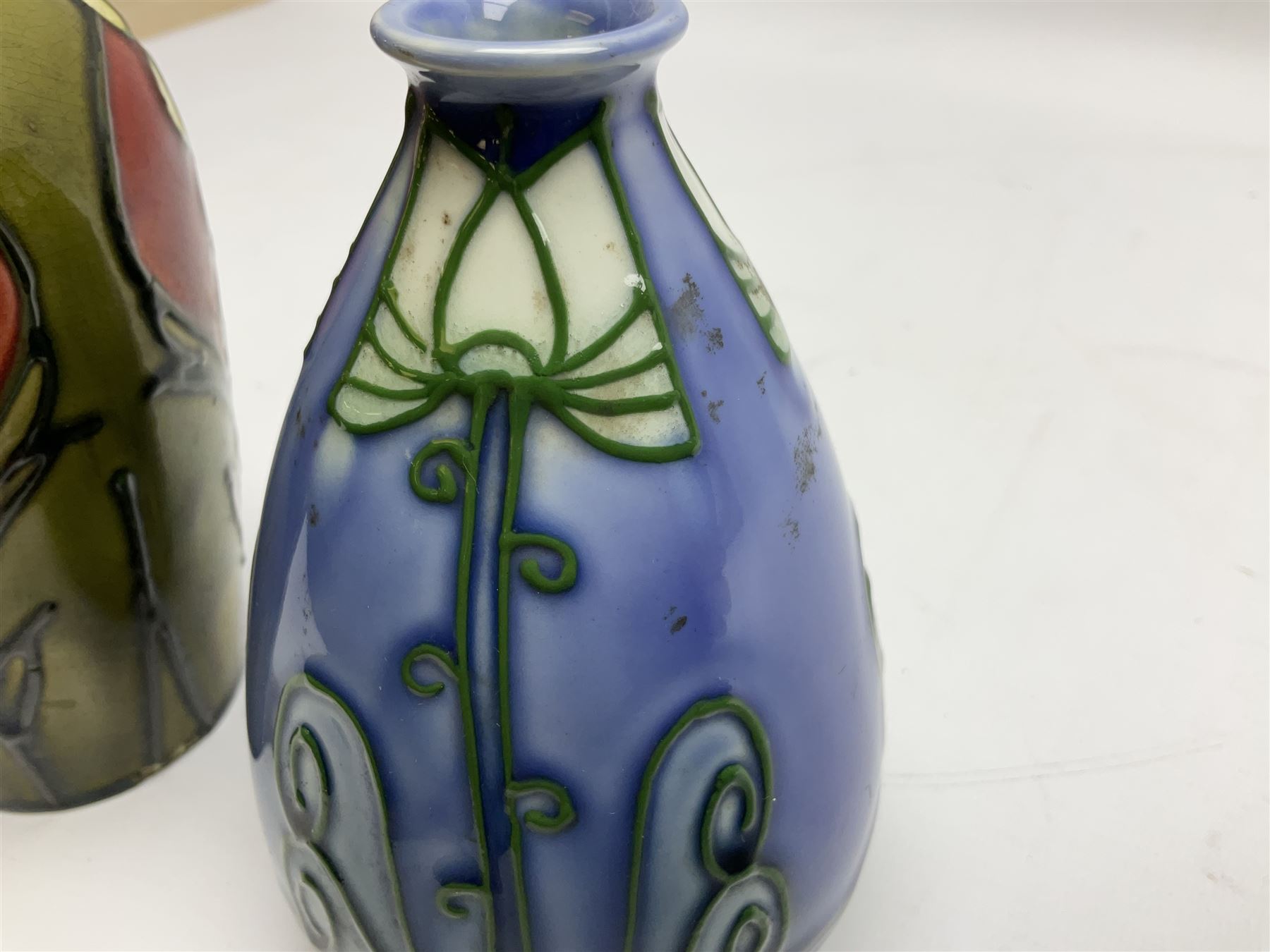 Minton Secessionist vase, with tube-lined stylised flower head decoration on a blue ground, printed mark to base 'Minton Ltd, No. 30', together with another Minton Secessionist tubelined vase,  printed mark to base 'Minton Ltd, No. 16', tallest example H13.5cm