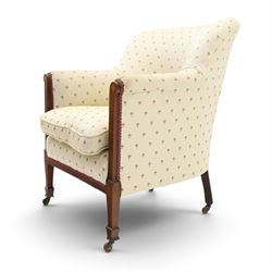 Edwardian inlaid mahogany armchair of modest proportions, spoonback and loose seat cushion on sprung seat upholstered in ivory ground floral fabric, on square tapering supports with ceramic castors