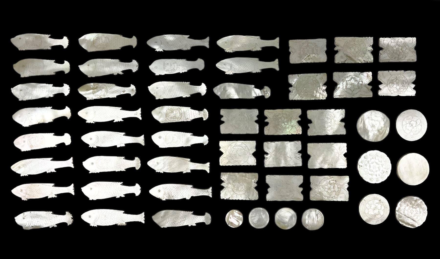 Collection of fifty two Chinese mother of pearl gaming counters or tokens, of various size and form including rectangular, circular and fish shaped examples, various decoration including floral motifs, largest rectangular examples L4cm