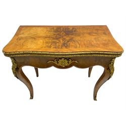 20th century French walnut and Kingwood card table, shaped fold-over top with figured quarter-matched veneers and floral egg and dart moulded edge in gilt metal, shaped aprons decorated with shell motifs with extending foliage, pull-out action base revealing storage well, on cabriole supports with ornate gilt metal mounts 
