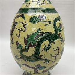 20th century Chinese Famille Verte vase, of slender ovoid form with tapering neck and flared rim, decorated with green and grey enamel with dragons chasing flaming pearls amongst auspicious clouds upon a yellow ground, H30cm