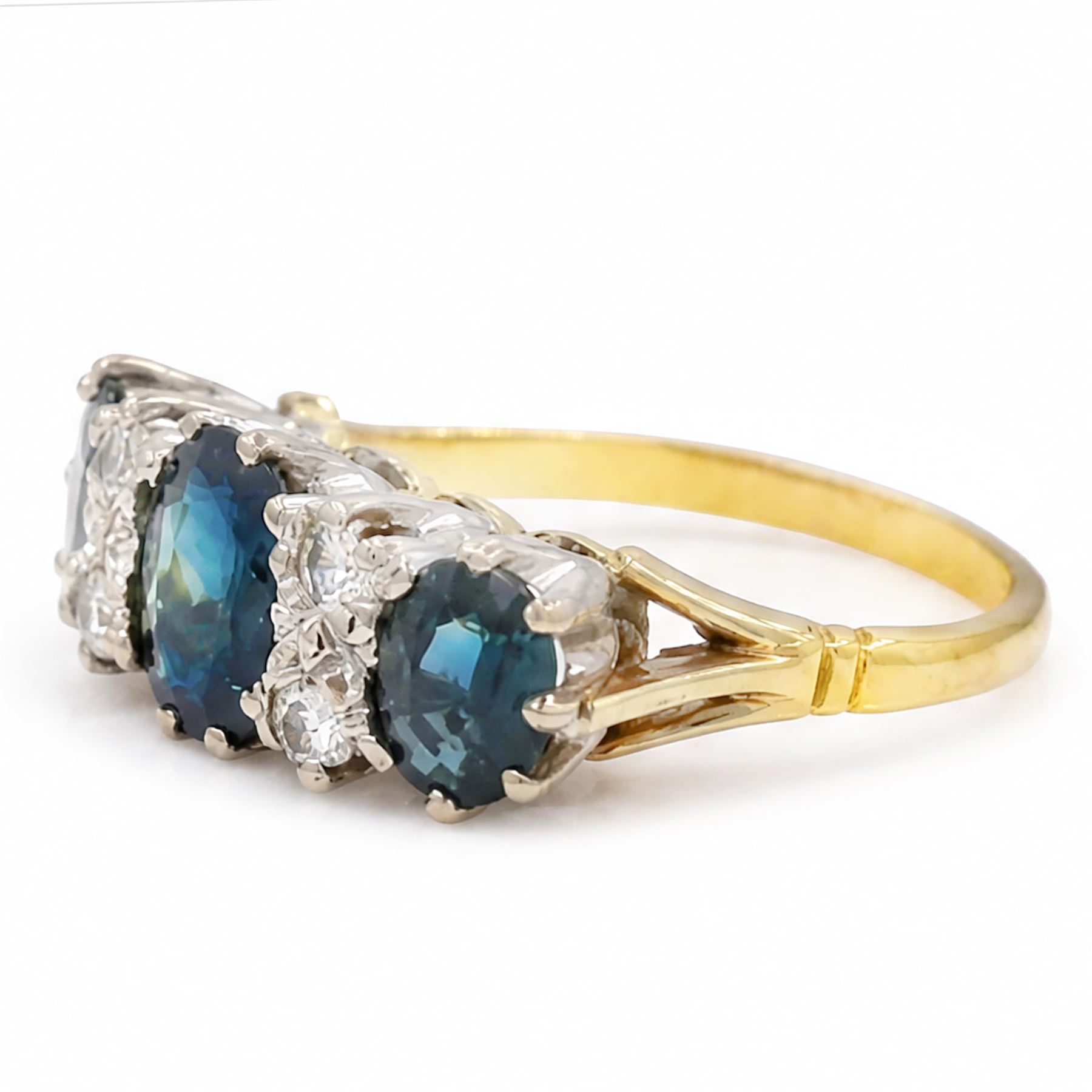 18ct gold sapphire and diamond ring, three graduating oval cut sapphires, the principal stone with two round brilliant cut diamonds set either side, London 1975, total sapphire weight approx 2.70 carat