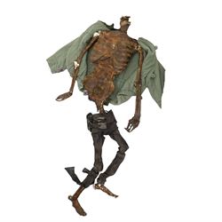 FILM PROPS; four decomposing prop cadavers, each with articulated joints and limbs, likely from a TV or film production, each prop displays intricate detailing with realistic aging and weathering, with a body bag