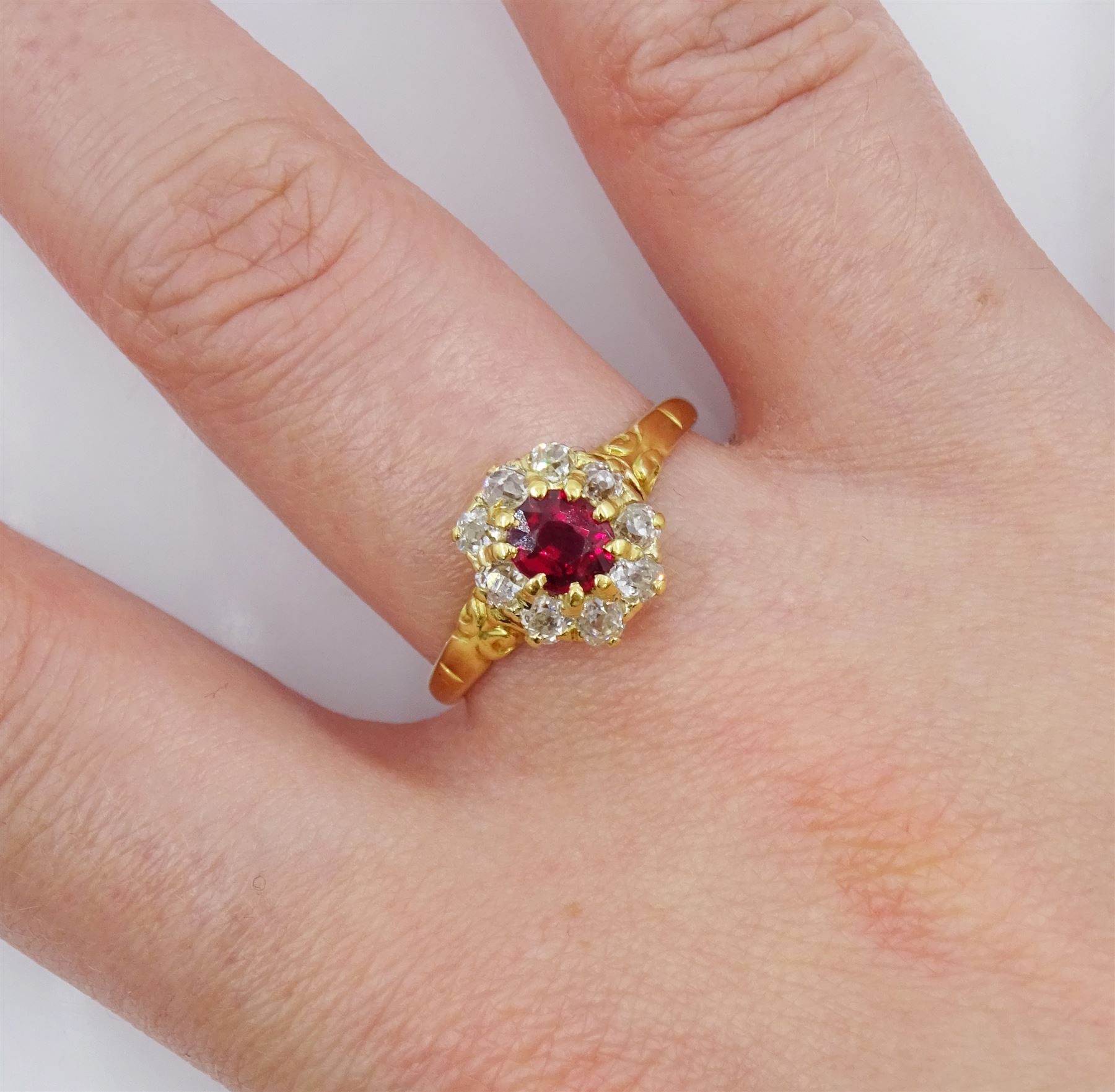 Early 20th century 18ct gold oval cut ruby and old cut diamond cluster ring, stamped, ruby approx 0.45 carat, total diamond weight approx 0.35 carat