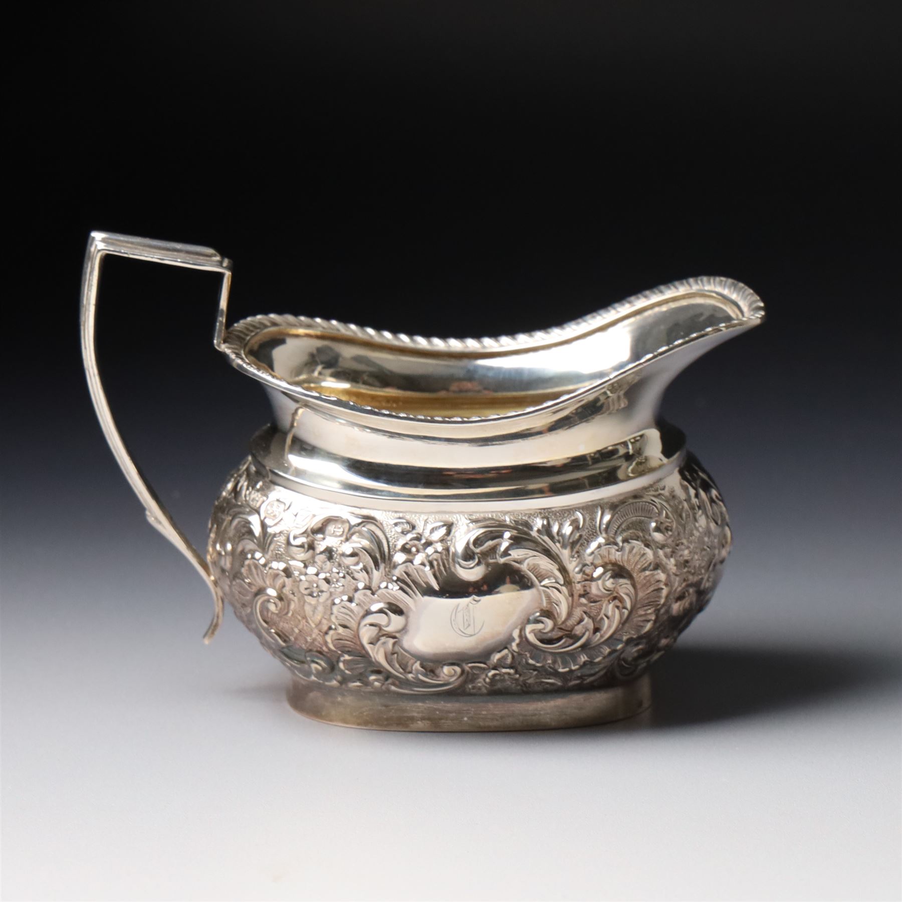 Late Victorian four piece silver tea set comprising teapot, coffee pot, sugar bowl and milk jug with embossed decoration, the cartouches engraved with an initial, the teapot and coffee pot Chester 1899 Maker George Nathan & Ridley Hayes, the sugar bowl and milk jug Birmingham 1899 Maker Thomas Hayes
