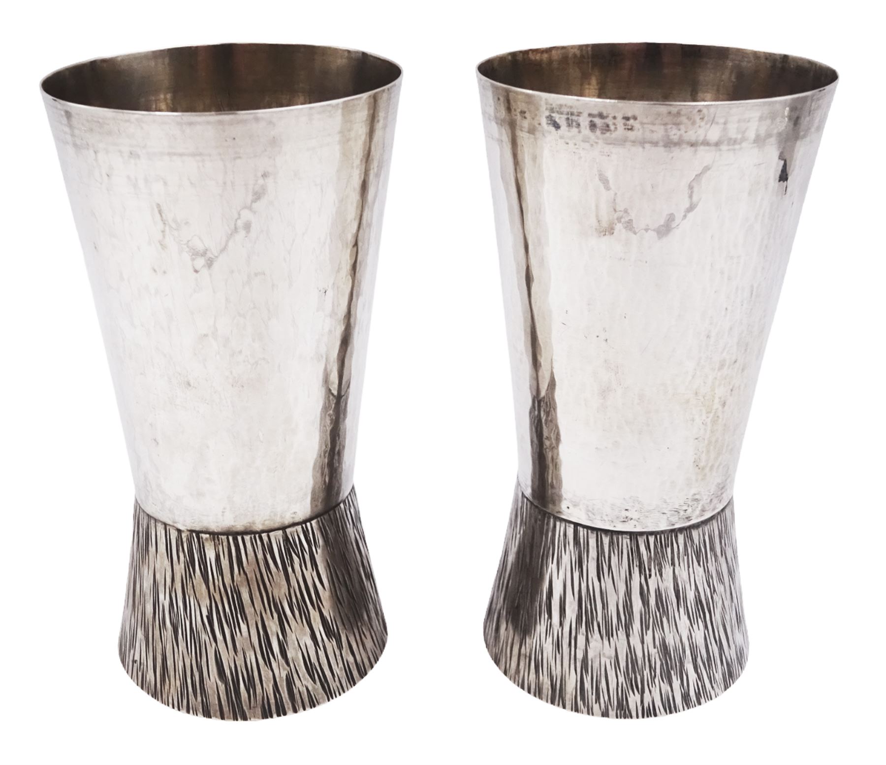 Pair of modern Guild of Hull Silversmiths silver goblets, the bowls each of tapering cylindrical form, with spot hammered finish, upon a tapering foot, etched with abstract lines, hallmarked J & KR, Birmingham 1983, also marked with the three crowns mark of the Guild of Hull Silversmiths, H11.6cm
Notes: Abraham Barachin was the last Hull silversmith to use the Hull mark of three ducal coronets in around 1706. However in 1983 the Assay Offices of Great Britain and the City of Kingston upon Hull granted the Guild of Hull Silversmiths permission to use the City's Coat of Arms as an additional mark on pieces they produced