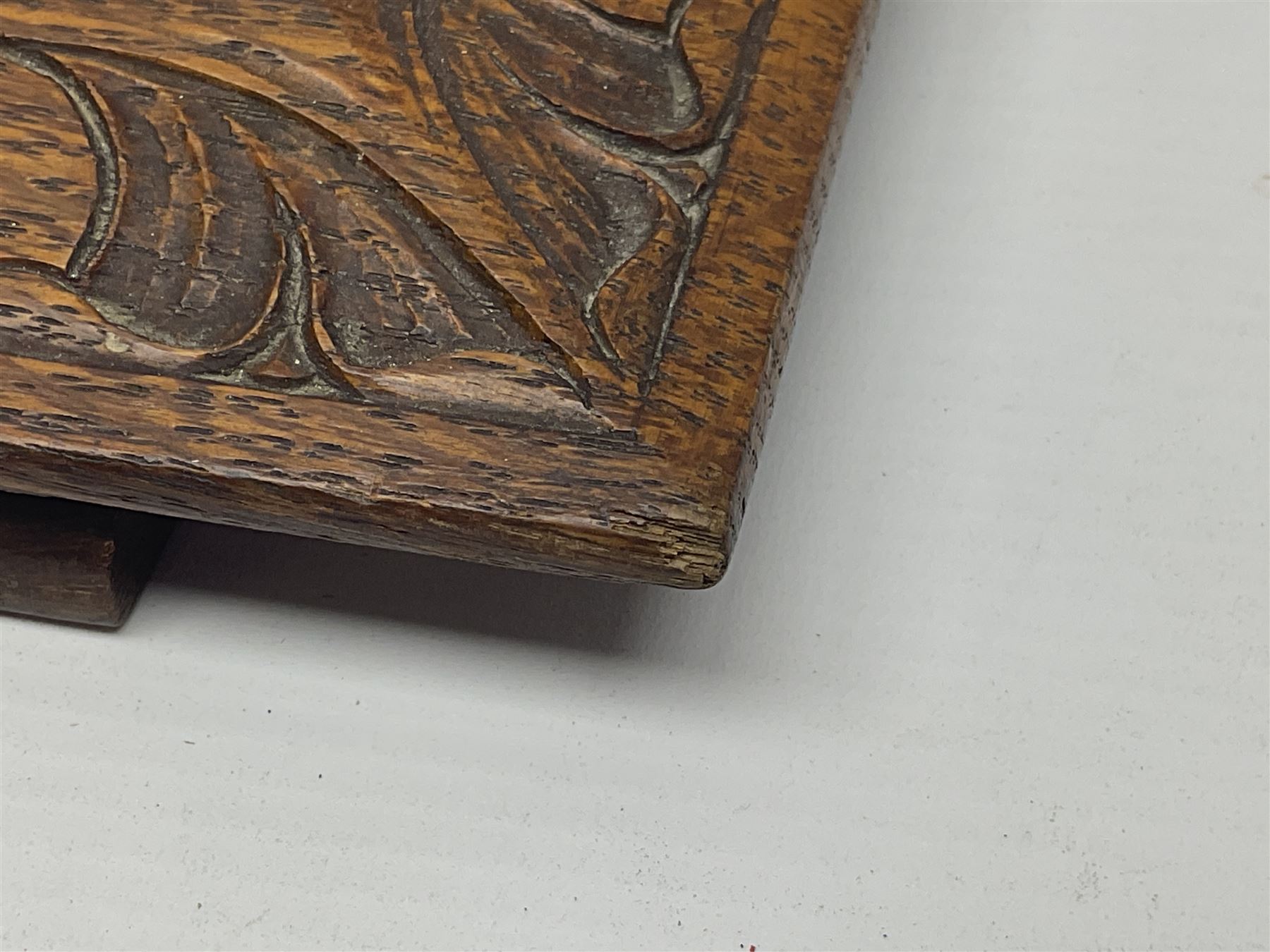 Arts and Crafts oak stand by Arthur Simpson of Kendal, of rectangular form with central hammered pewter panel, surrounded by a border with carved foliate corners, upon two bar supports, bearing label detailed 