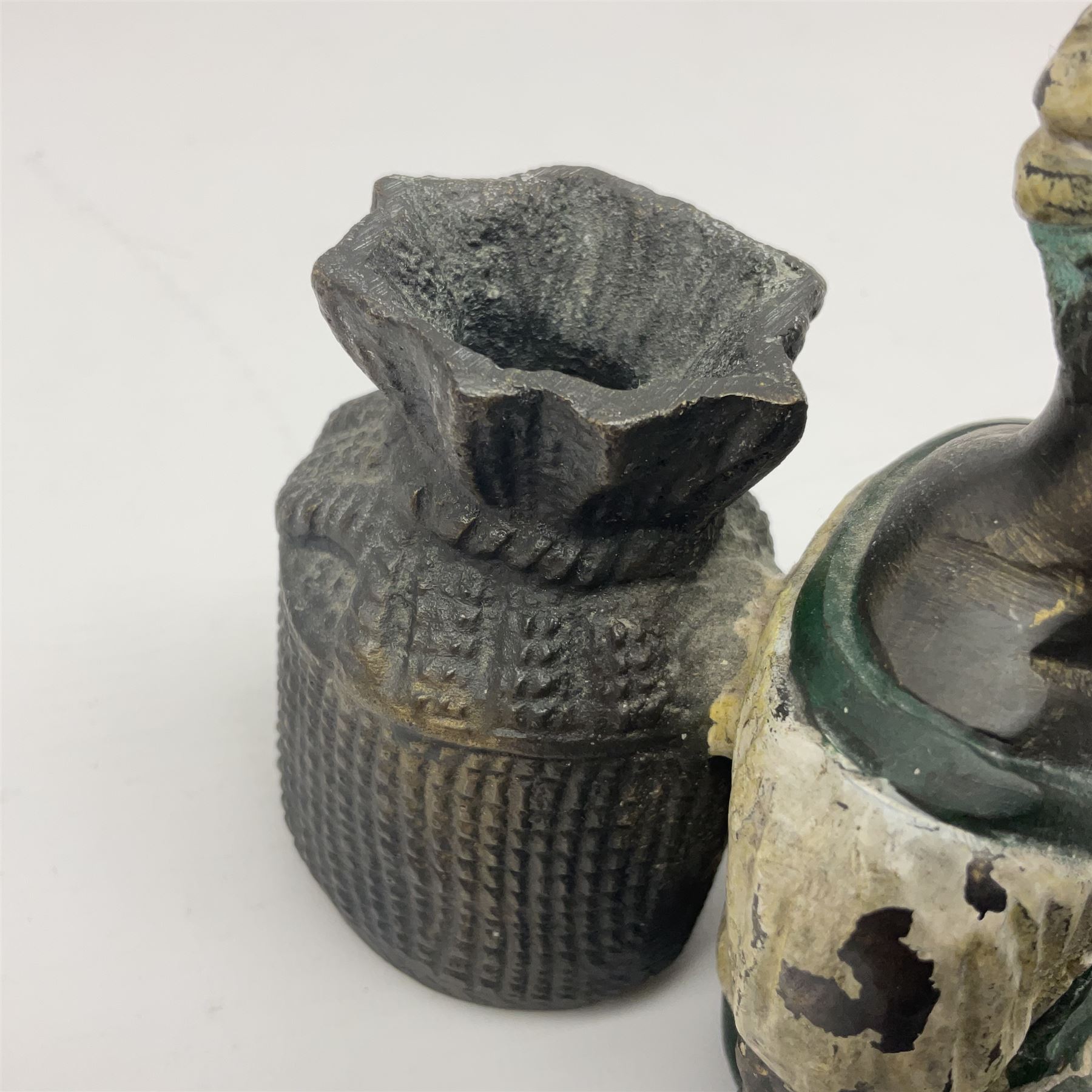 Bronze figure of a seated man resting on a sack