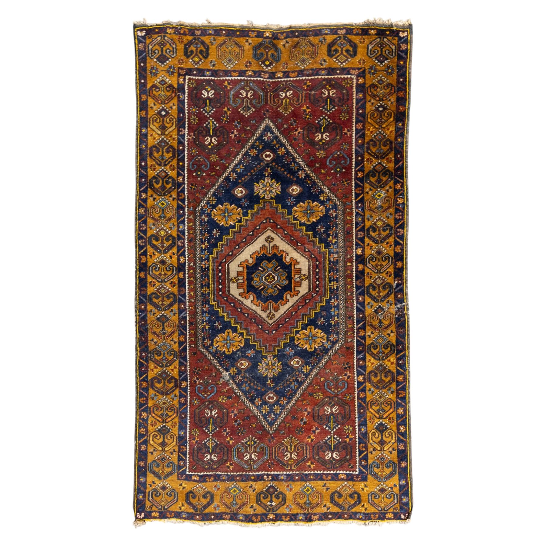 Turkish Anatolian wool rug, central stepped medallion on dark blue lozenge field, red spandrels with stylised hooked motifs, ochre border decorated with repeating geometric motifs and guard stripes