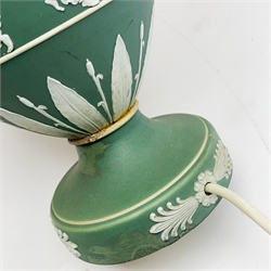 A Wedgwood green Jasperware table lamp, of ovoid form upon a spreading circular foot, decorated with dancing hours, with cream shade, overall H44.5cm. 