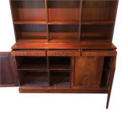 Early 20th century mahogany open bookcase, with reeded upright divisions and adjustable shelves, over a cupboard base fitted with three frieze drawers and three panelled doors, on plinth base