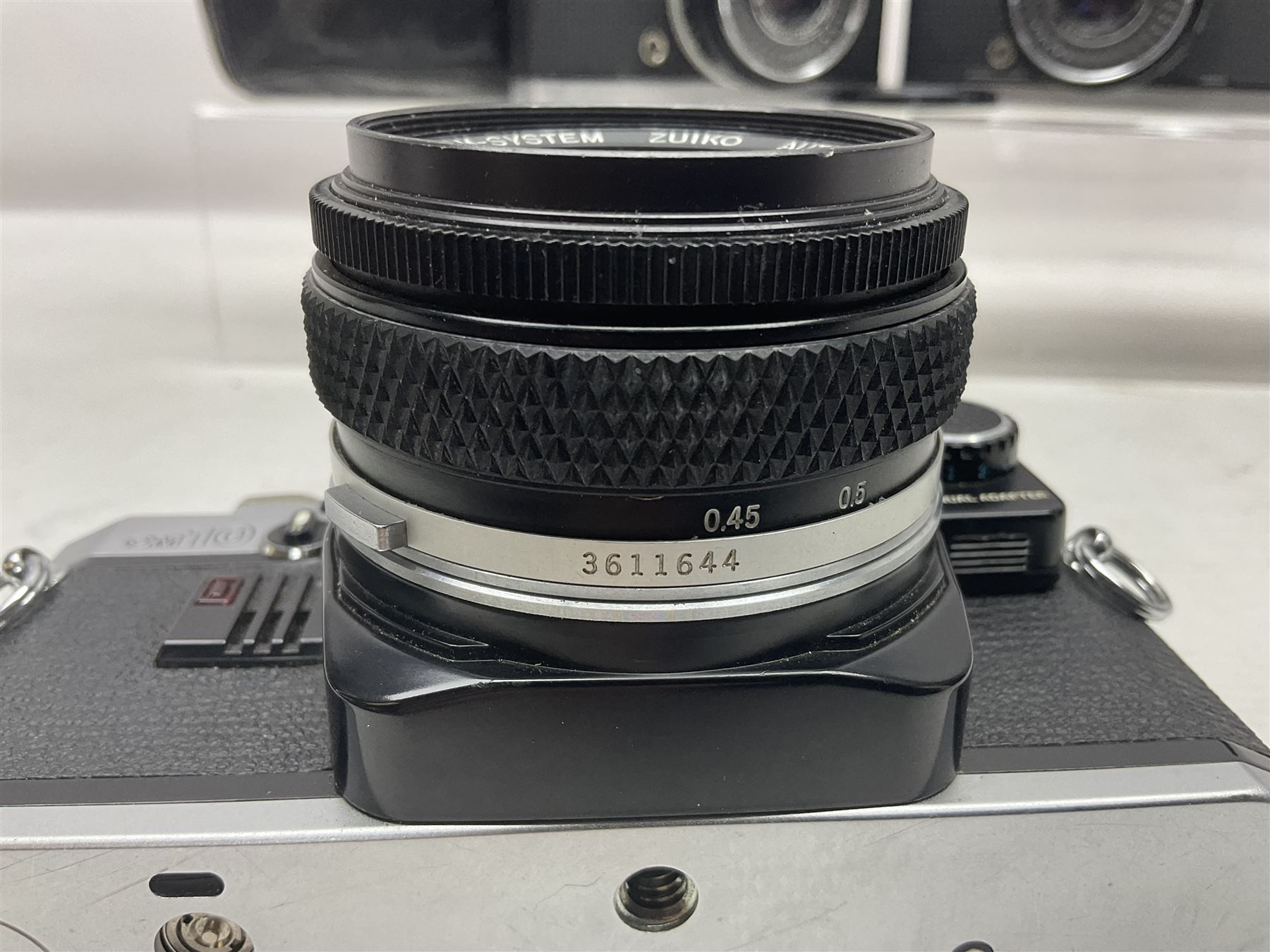 Four Olympus camera bodies, including Olympus OM10, serial no 20744269, with 'Olympus OM-System Zuiko Auto-S 50mm 1:1.8' lens serial no 3633644, Olympus OM-2 camera body serial no 460280 with 'Olympus OM-System G.Zuiko Auto-s 1:1.4 f=50mm' lens, serial no 729750, etc 