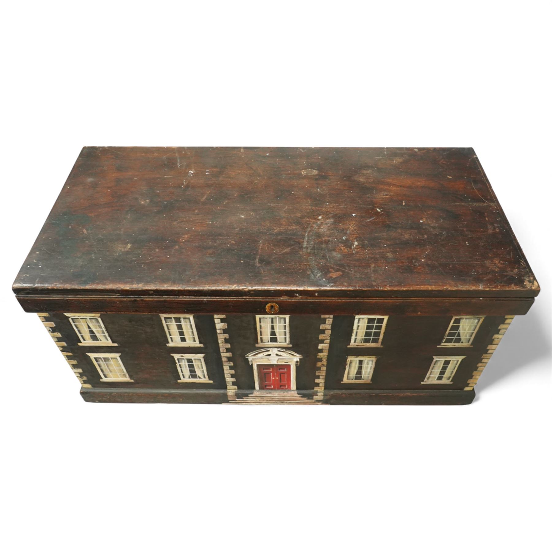 Georgian style painted wooden country house box, the rectangular hinged lid enclosing a plain interior, the exterior decorated as a symmetrical Georgian facade with sash windows, and central stepped and pedimented doorway, with moulded base and top edge