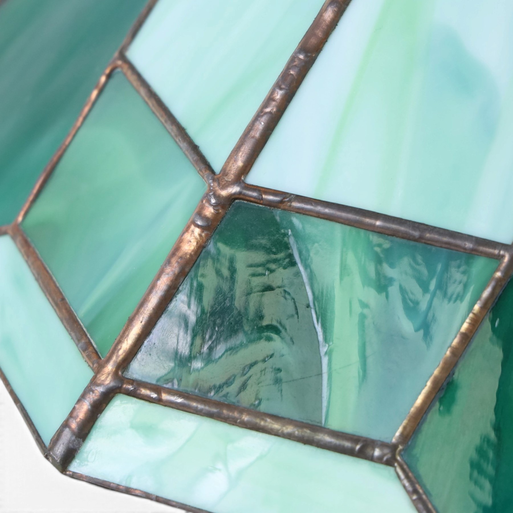 Pair of Tiffany style green stained glass shades with geomatic design, D50cm