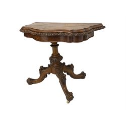 Victorian walnut serpentine card table, the stepped hinged and swivel top with moulded and egg and dart edges, figured frieze, turned pedestal on four splayed supports carved with fruit and berries, on ceramic castors