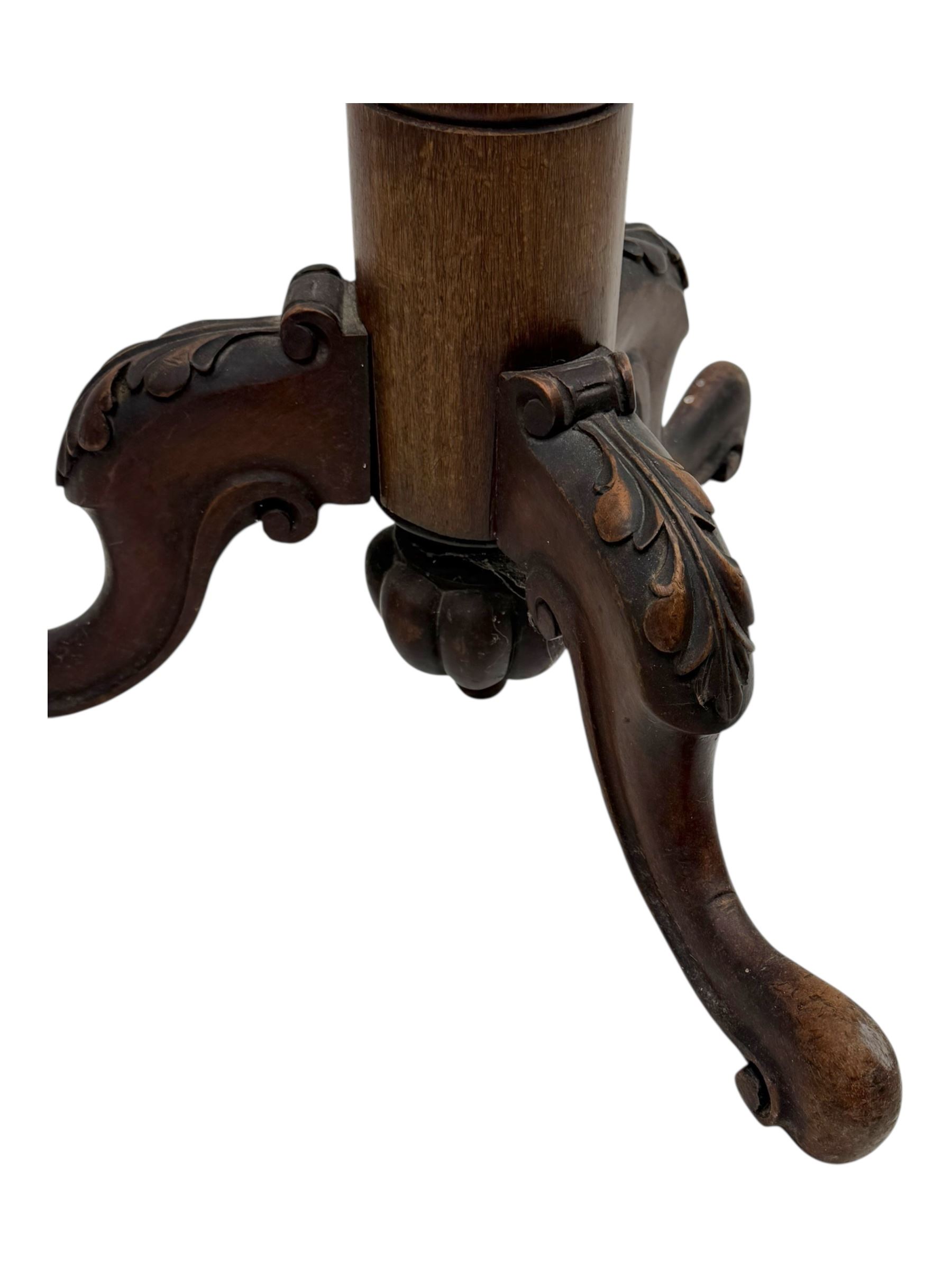 Late 19th century mahogany torchère stand, with circular top above a twisted and foliate carved collumn, on a scroll carved tripod base, on cabriole legs